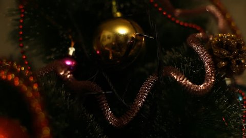 Flashing Christmas lights garland on a Christmas tree decorated with Christmas balls