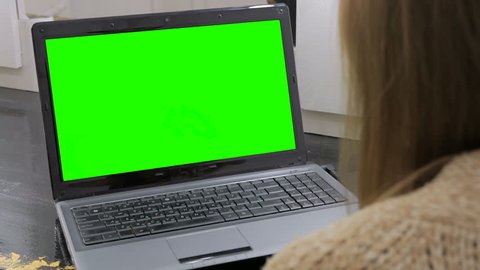 Woman looking at laptop with green screen. Business, communication, freelance and internet concept