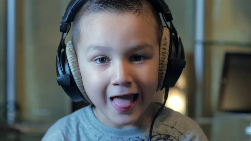 The boy listens to hard rock in headphones