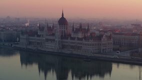 The Hungarian Parliament overlooking the river Danube in Budapest sunrise - aerial video