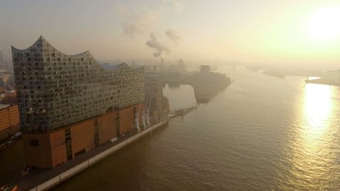 Aerial fly by shot of the Elbphilharmonie with view on the Hafencity and Grasbrookhafen in beautiful morning light.