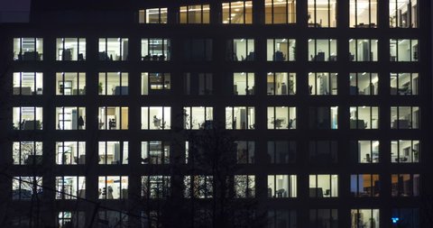 Office building in metropolitan area in late evening. People working 24 hours. Time lapse shot