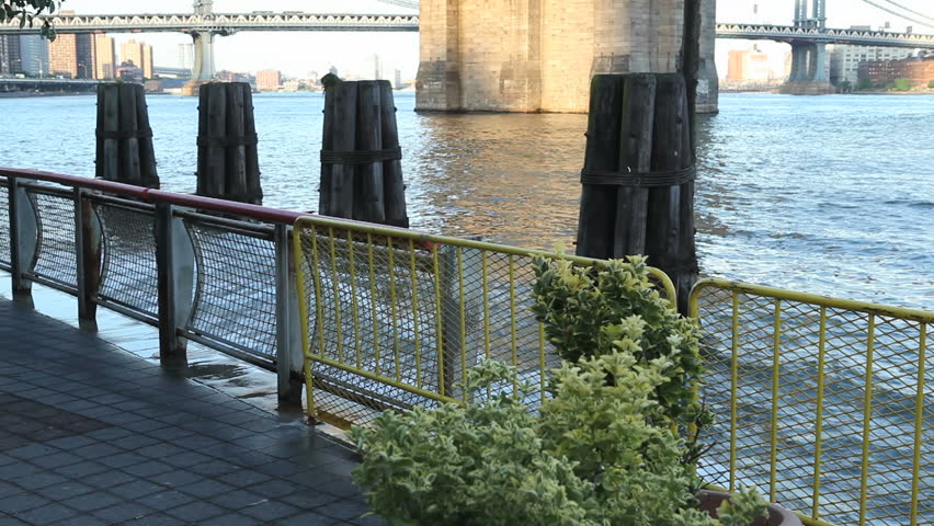 A wave splashes at the walkway under the Brooklyn Bridge
