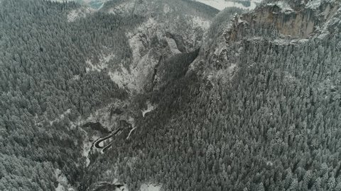Aerial footage of mountain ranges and cliffs covered with snow