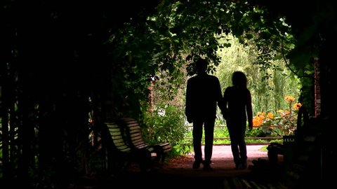couple silhouette in plant tunnel 