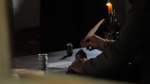 VIRGINIA - JULY 2016 - Reenactment, 16th - 18th Century era recreation -- Writing with a quill at candle light