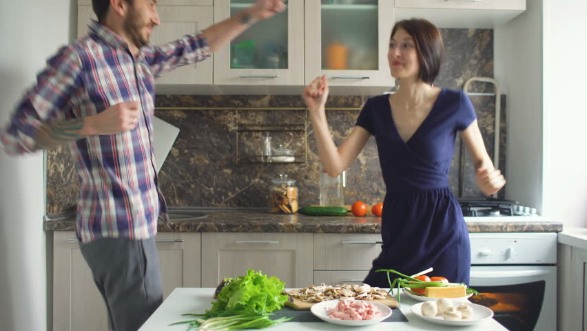 Happy beautiful couple dancing rocknroll while cook on the kitchen at home Royalty-Free Stock Footage #24370076