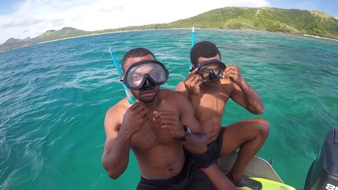 NADI, FIJI - DEC 20 2017:Indigenous Fijian men getting ready to snorkel in the Yasawa Islands of Fiji with Tourist.Fiji's annual Visitor Arrival number reached a new high of 792,320 in 2016.