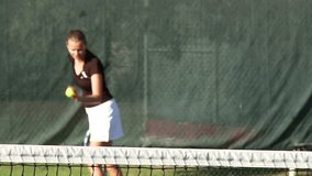 Girl serving tennis ball in slow motion
