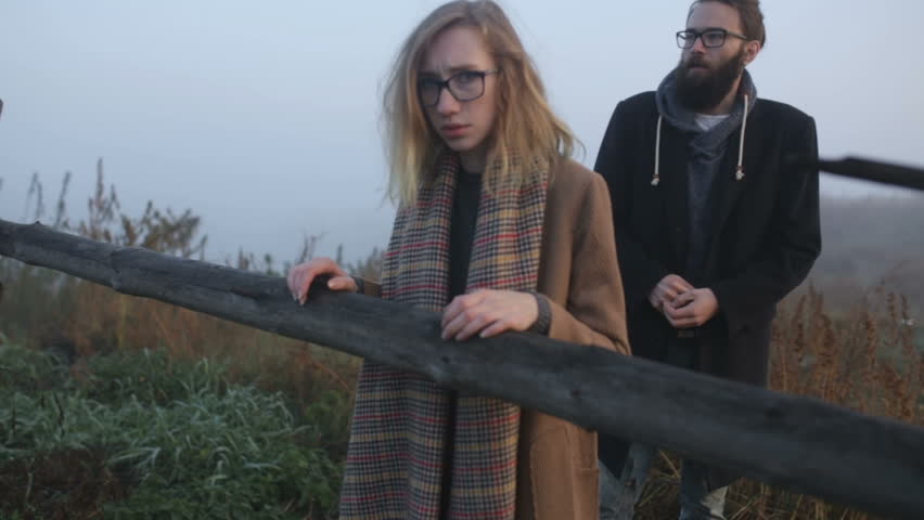 A pair of hipsters quarrel outdoors