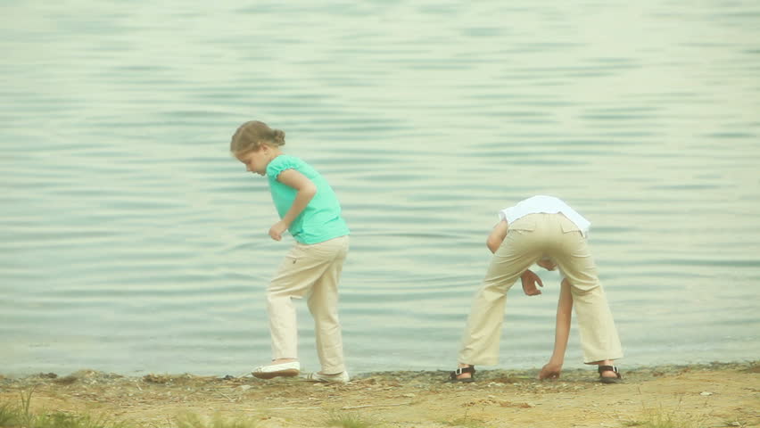 Kids on the beach of the lake skipping stones