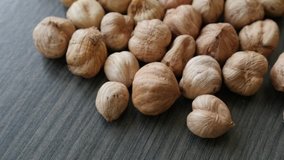 Lot of common hazelnuts on table close-up slow tilt  