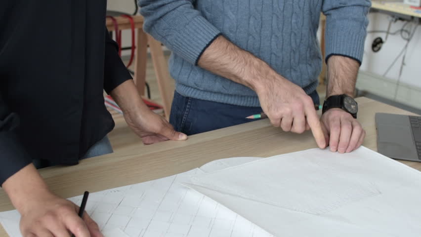 Unrecognizable man and woman working on a project at the table  