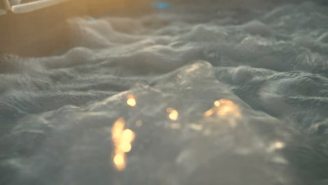 Water running in a bath tub with massaging water jets at the sunset on a luxury yacht
