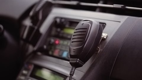 Policeman using radio station for communication sitting in the car