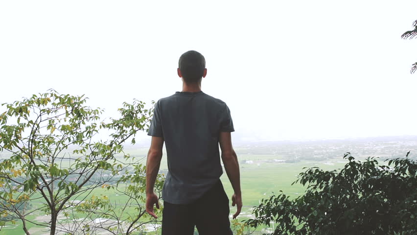 Successful man raising arms after cross track running on summer sunset. Fitness male athlete with arms up celebrating success and goals after sport exercising and working out.