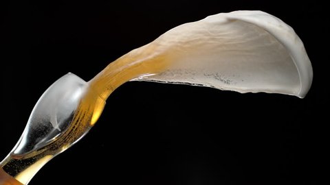 Beer spilled out of glass and making splash. Shot with high speed camera, phantom flex 4K. Slow Motion.