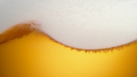 Extream close-up beer in glass. Foam moving. Shot with high speed camera, phantom flex 4K. Slow Motion.