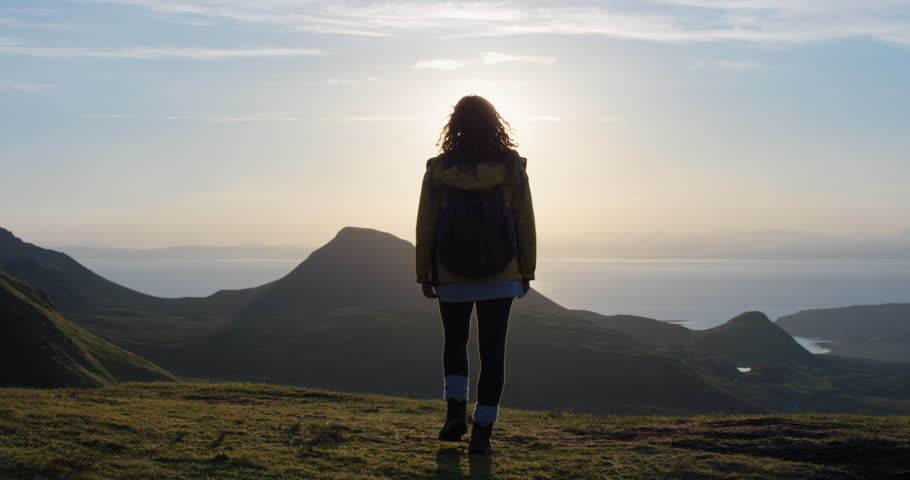 Woman with arms raised on top of mountain looking at Sunset view Hiker Girl lifting arm up celebrating life scenic nature landscape enjoying vacation travel adventure Isle of Skye Scotland Royalty-Free Stock Footage #24428360