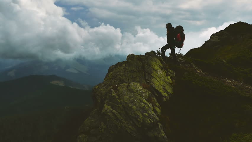 A woman stands on a hilltop