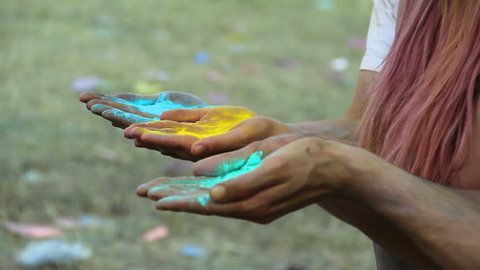 Happy faces of best friends blowing powder paint into the air at Holi festival Video Stok