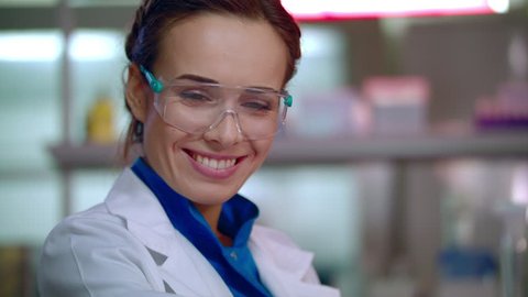 Woman scientist smiling. Happy scientist portrait in safety glasses. Scientist face. Female lab scientist smile. Closeup of lab woman happy face. Lab woman smiling