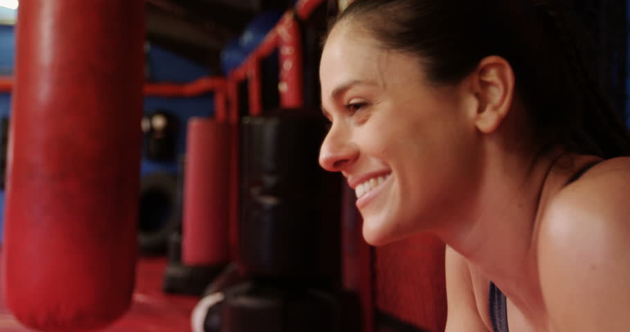 Portrait of smiling Caucasian female boxer standing in fitness studio