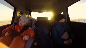 Children riding in the car. The sun's rays through the glass. Slow motion