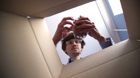 Man opening a Food delivery box at home. Food delivery services during coronavirus pandemic for working from home and social distancing. Shopping online.