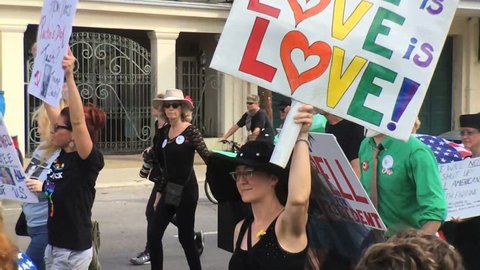 NEW ORLEANS, LOUISIANA - JANUARY 20, 2017  Woman holds Love is love sign during anti Donald Trump march mock jazz funeral parade protest lady liberty 