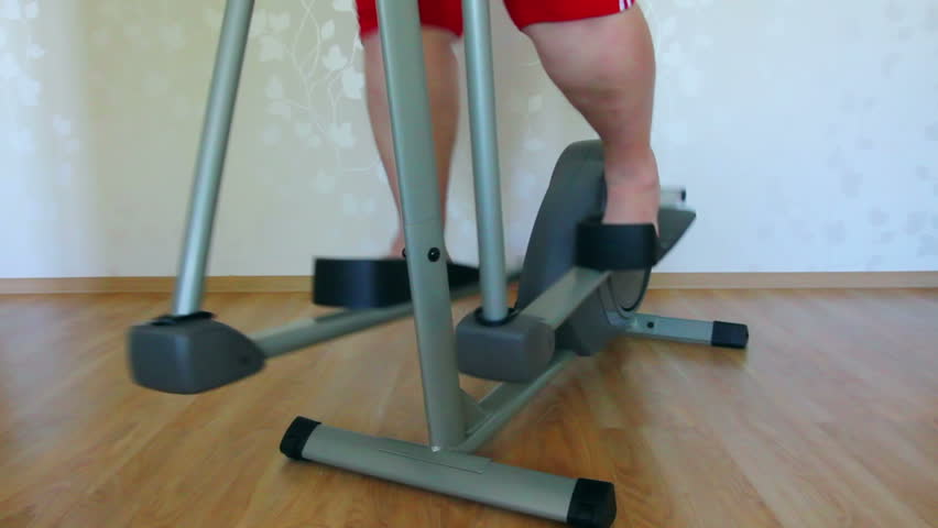 overweight woman legs exercising on trainer ellipsoid