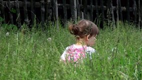 two-year old girl walking on meadow