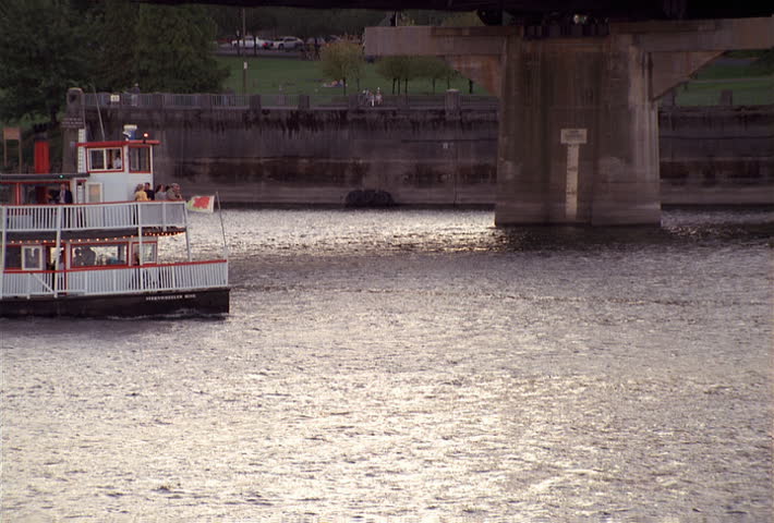 River excursion boat with paddle wheel passing under bridge in Portland, Oregon