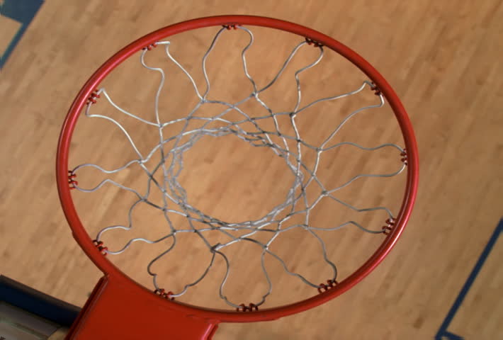 Overhead slow motion view through basketball hoop: ball going in