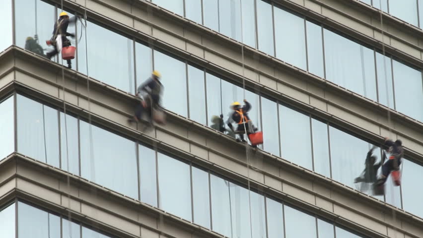 Window Washers - Climber cleaning modern building glass wall