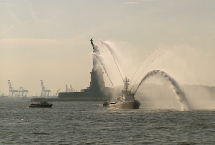 NEW YORK - Circa 2002: Fire boat shooting a water canon salute in front of the Statue of Liberty in 2002.