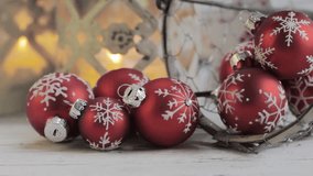 Christmas baubles and burning candles in the backgrounds