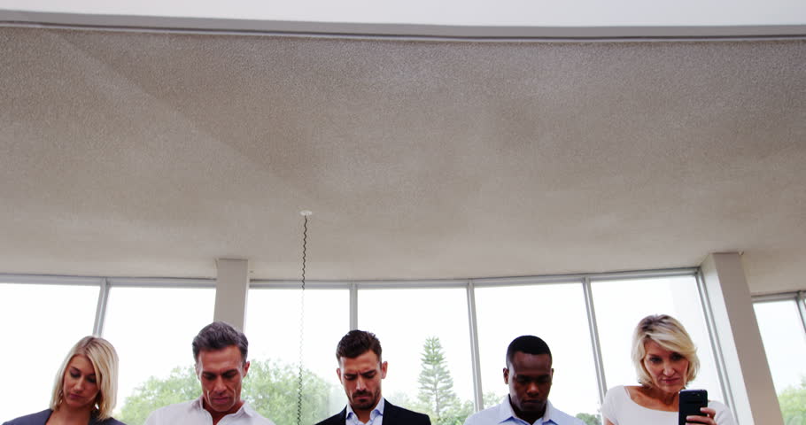 Business executives using mobile phone at conference center