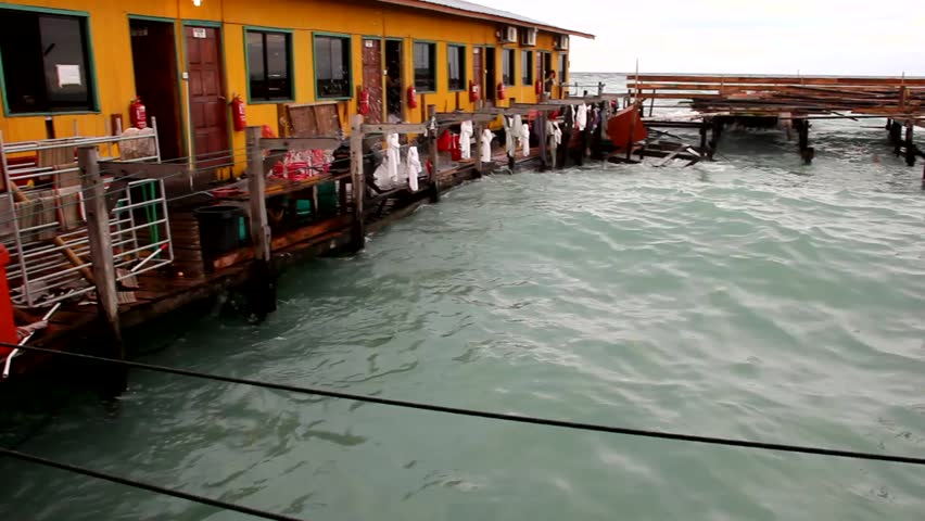 Waves of rough sea flooding Polynesian style hotel in the island of Mabul, Borneo, Malaysia