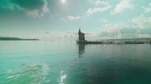 Slow motion shot of the harbor of Konstanz - Bodensee. View with beautiful light reflections, a blue sky and some clouds. Variation 2.