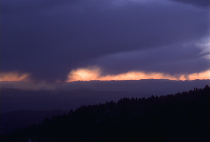 Time-lapse darkening sky over mountain ridges