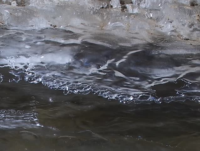 A small creek is covered in snow and ice