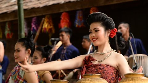 December 3, 2016, Nakhon Ratchasima. Isan women wearing traditional clothes dance to local music, with musicians playing in the background. Travel and culture concept.