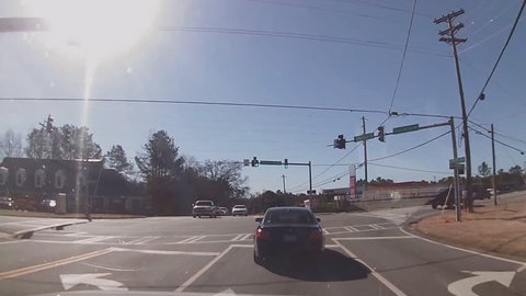 Careless distracted driver runs red traffic light and narrowly escapes being hit by several other vehicles.