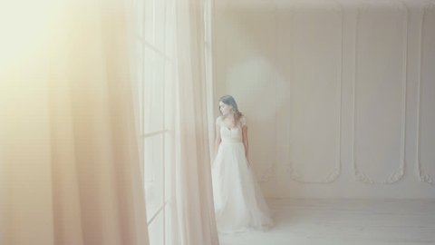 beautiful bride looking at the big screen in a bright room in slow motion