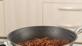 Tinned tomatoes being added to minced meat