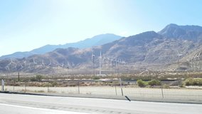 Driving by a large field of wind power generators, on interstate 10, just outside Los angeles, california, in united states of america