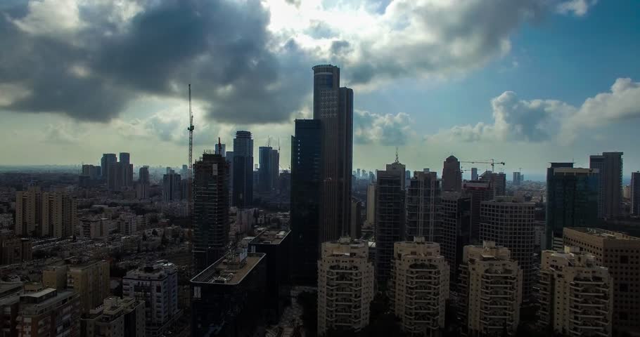 Vertical ascent movement of Aerial view of tel aviv skyline with urban skyscrapers at sunset, with cloudy sky, Israel