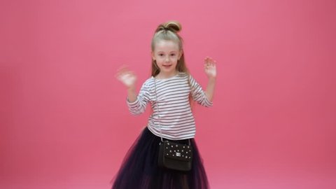 Cute young girl dancing on a blue background