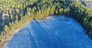 Cinema 4k aerial flight away from a wooden pier and a icy pond, in Kaskimaa, Raasepori, Finland.